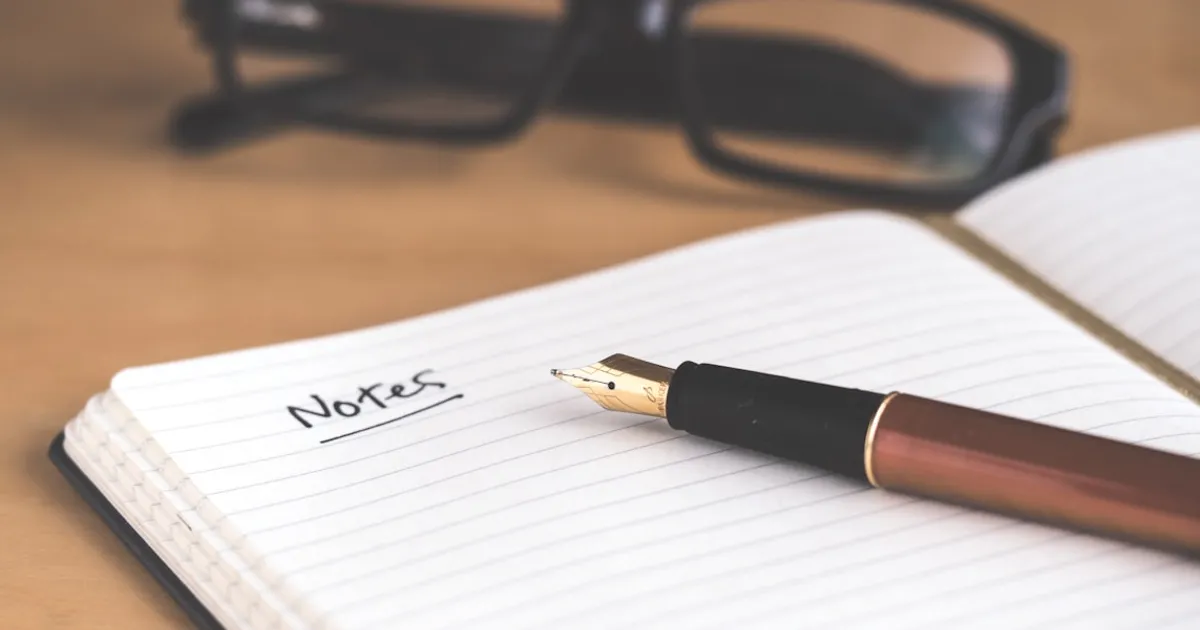 Journal de rêves ouvert sur une table de chevet avec un stylo